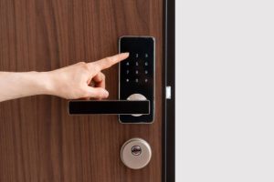 A hand pressing a numeric keypad on a digital door lock mounted on a wooden door. Locksmith in Lawrence Manor Locksmith in Topham Park