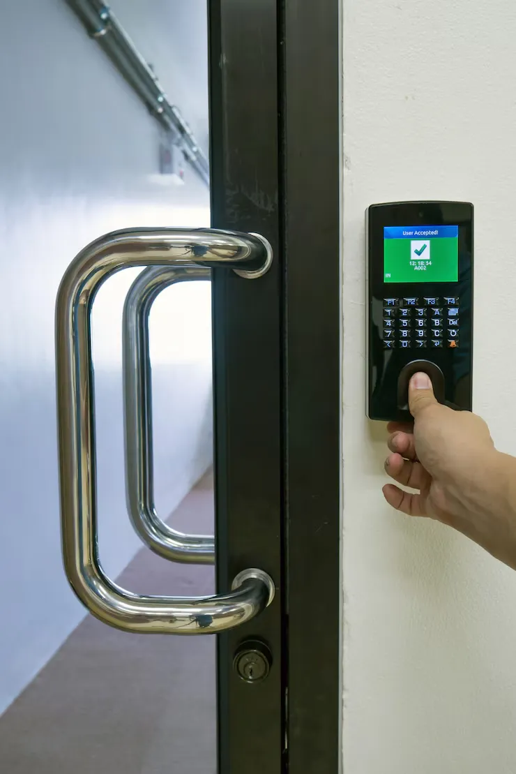 A hand enters a code on a keypad access control system next to a metal door handle, with a green screen displaying "Access Granted. Access Control System Access Control for Toronto Retail Stores: Affordable Options That Work