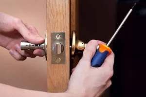 A person uses a screwdriver to install or remove a door lock on a wooden door. Locksmith in Birchcliffe Locksmith in Flemingdon Park Locksmith in Harbourfront
